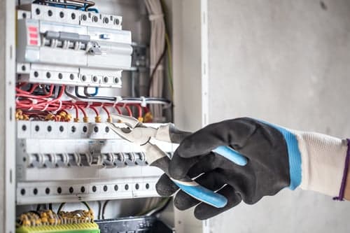 Licensed electrician working inside a residential electrical panel in Palmdale, California